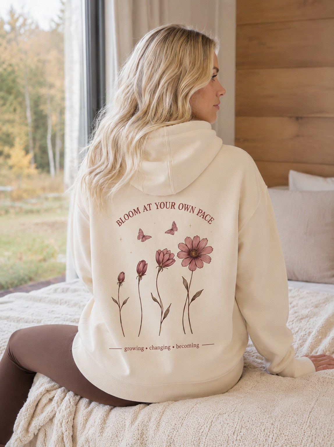 Šviesiai kreminis džemperis moterims su gobtuvu ir „Bloom At Your Own Pace“ gėlių spauda nugaroje